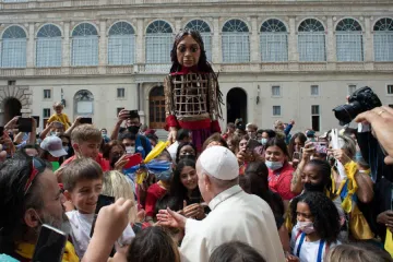 Pope Francis greets children in the San Damaso Courtyard during the puppet Little Amal’s visit to the Vatican, Sept. 10, 2021